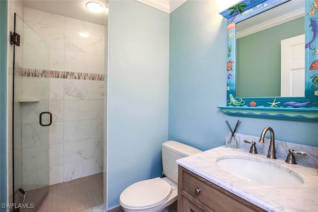 bathroom with a stall shower, toilet, vanity, and ornamental molding