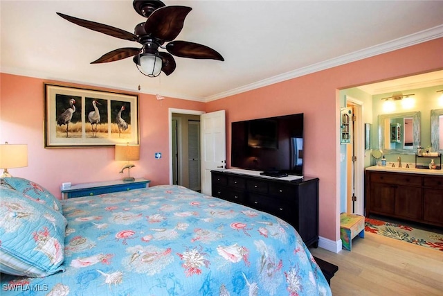 bedroom with crown molding, wood finished floors, a ceiling fan, a sink, and connected bathroom