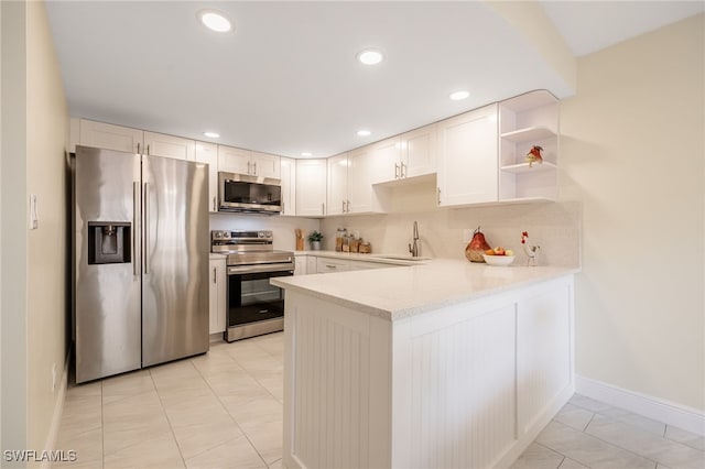 kitchen with appliances with stainless steel finishes, a peninsula, baseboards, open shelves, and recessed lighting