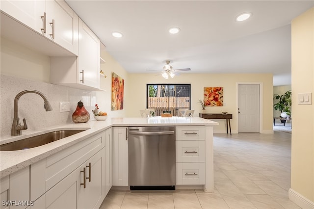 kitchen featuring stainless steel dishwasher, a sink, a ceiling fan, a peninsula, and backsplash