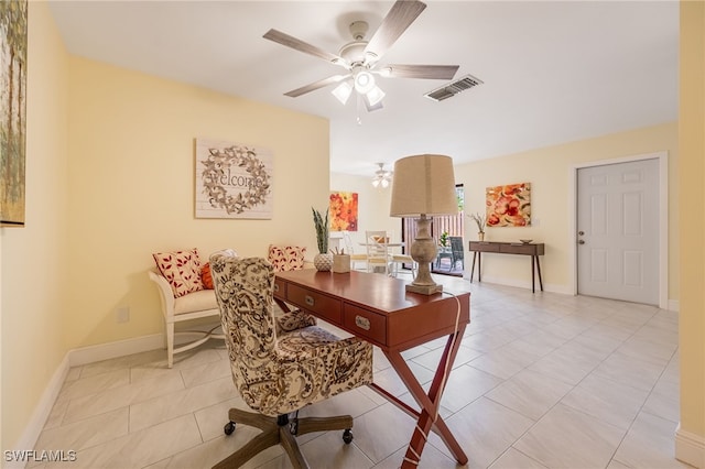 office featuring a ceiling fan, light tile patterned floors, and baseboards