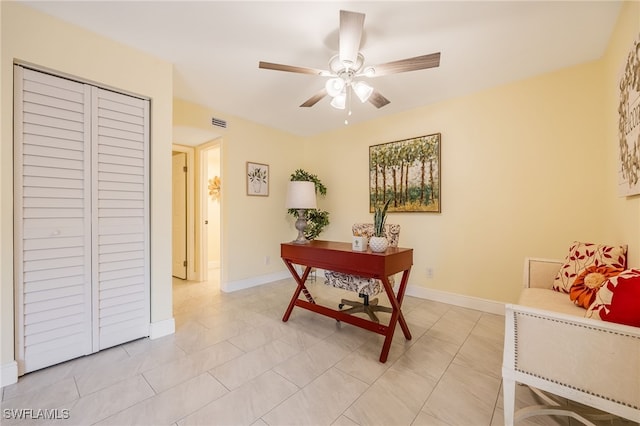 home office featuring ceiling fan, baseboards, and light tile patterned flooring