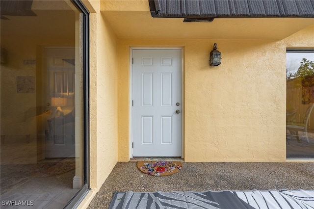 doorway to property featuring stucco siding