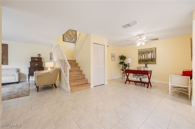living room featuring a ceiling fan, stairs, and baseboards