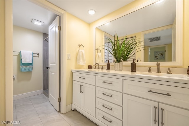 full bath featuring baseboards, double vanity, marble finish flooring, and a shower