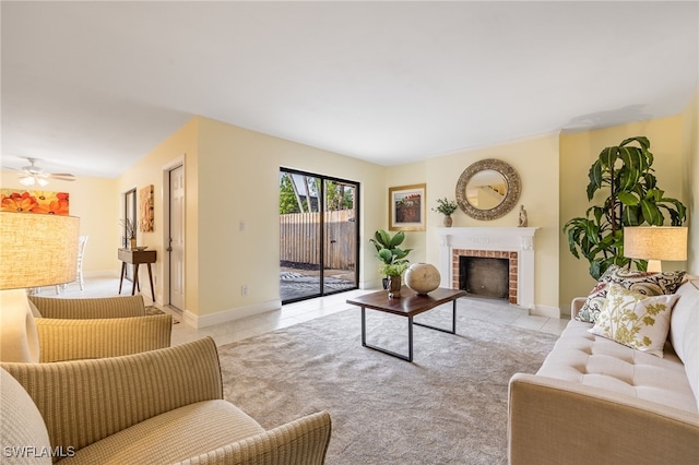 tiled living room featuring a fireplace, a ceiling fan, and baseboards