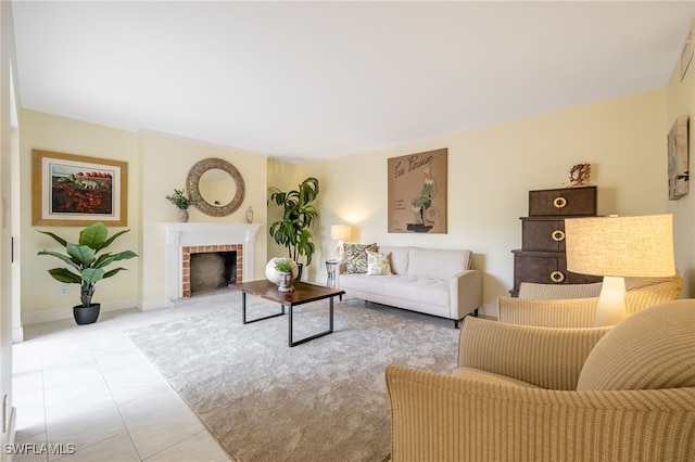 living room with a brick fireplace, tile patterned floors, and baseboards