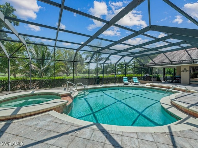 view of pool featuring a pool with connected hot tub, a patio, and a lanai