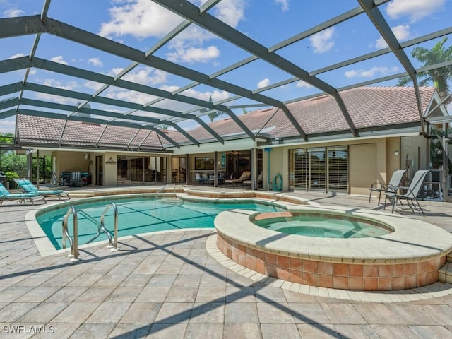 view of pool featuring a patio, a pool with connected hot tub, and glass enclosure