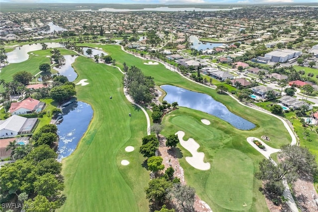 view of property location featuring nearby suburban area, a golf course, and a nearby body of water