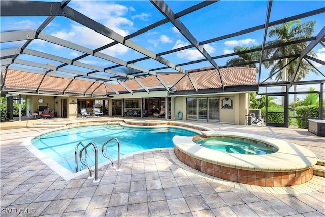 view of swimming pool featuring a patio area, glass enclosure, and a pool with connected hot tub