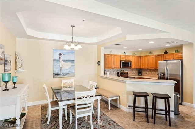 1520 SW 50th St Unit 202, Cape Coral, FL 33914 - dining space with a tray ceiling, a chandelier, light tile patterned flooring, recessed lighting, and baseboards