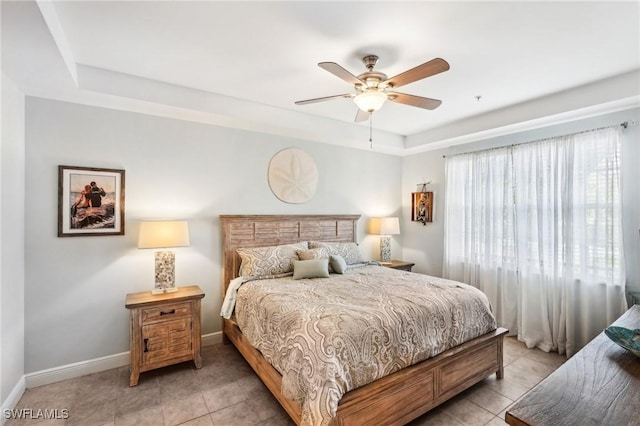 1520 SW 50th St Unit 202, Cape Coral, FL 33914 - bedroom with baseboards, light tile patterned flooring, a ceiling fan, and a tray ceiling