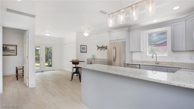 767 Glendale Ave, Naples, FL 34110 - kitchen featuring appliances with stainless steel finishes, healthy amount of natural light, light stone counters, light wood-style flooring, and recessed lighting
