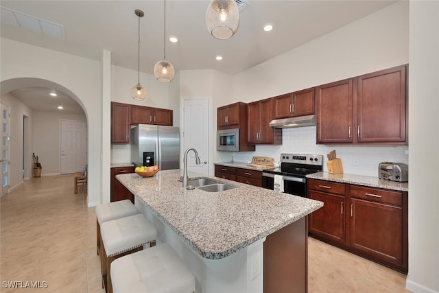 20956 Corkscrew Shores Blvd E, Estero, FL 33928 - kitchen with appliances with stainless steel finishes, under cabinet range hood, arched walkways, tasteful backsplash, and a sink