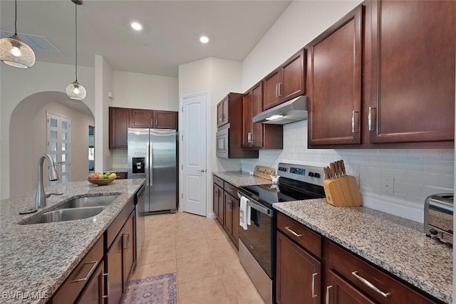 20956 Corkscrew Shores Blvd E, Estero, FL 33928 - kitchen featuring appliances with stainless steel finishes, a sink, under cabinet range hood, arched walkways, and tasteful backsplash