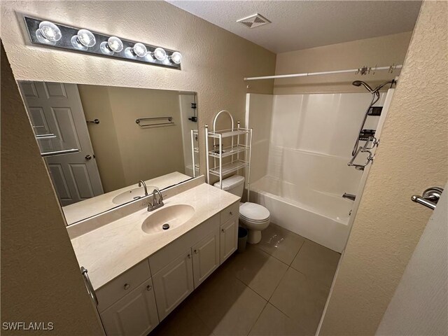 5550 Birdsong Ln, Bokeelia, FL 33922 - bathroom with a textured wall, tile patterned flooring, a textured ceiling, vanity, and toilet