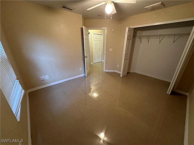 5550 Birdsong Ln, Bokeelia, FL 33922 - unfurnished bedroom with baseboards, tile patterned floors, a ceiling fan, and a closet
