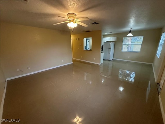 5550 Birdsong Ln, Bokeelia, FL 33922 - unfurnished room with light tile patterned floors, ceiling fan, a textured ceiling, and baseboards