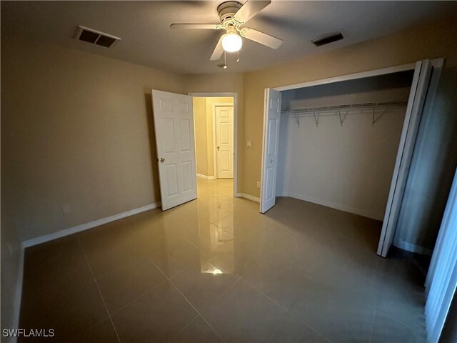 5550 Birdsong Ln, Bokeelia, FL 33922 - unfurnished bedroom featuring tile patterned floors, a closet, baseboards, and a ceiling fan
