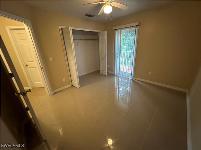 5550 Birdsong Ln, Bokeelia, FL 33922 - unfurnished bedroom featuring light tile patterned floors, baseboards, a closet, ceiling fan, and access to exterior