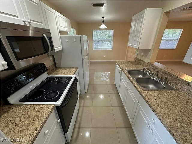 5550 Birdsong Ln, Bokeelia, FL 33922 - kitchen featuring white appliances, a sink, white cabinets, and baseboards