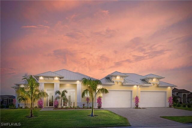 14931 David Dr, Fort Myers, FL 33908 - view of front facade featuring a standing seam roof, driveway, a front yard, an attached garage, and metal roof