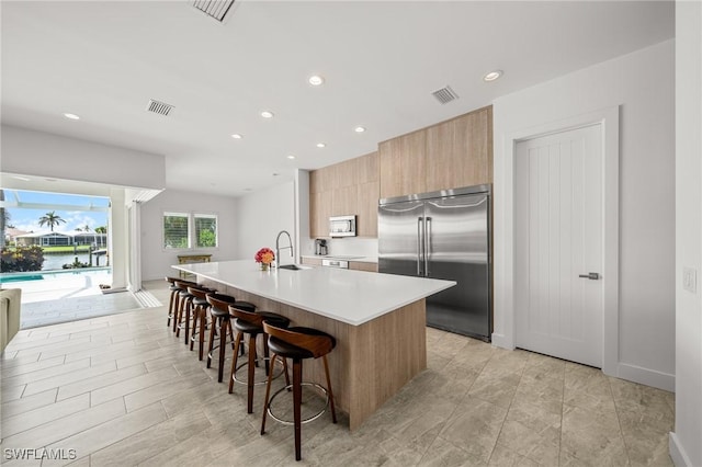 14931 David Dr, Fort Myers, FL 33908 - kitchen with appliances with stainless steel finishes, modern cabinets, light countertops, a sink, and a kitchen island with sink