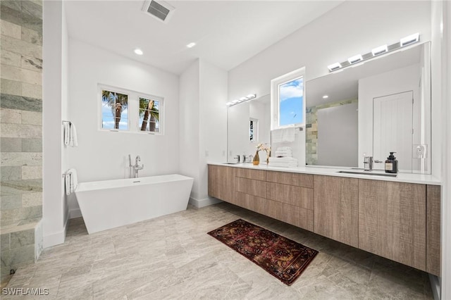 14931 David Dr, Fort Myers, FL 33908 - bathroom featuring a freestanding bath, a shower stall, double vanity, recessed lighting, and baseboards