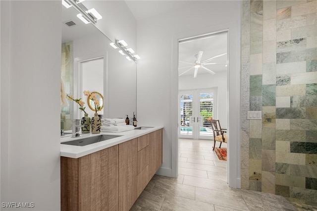 14931 David Dr, Fort Myers, FL 33908 - full bathroom with french doors, double vanity, ceiling fan, and tile patterned flooring