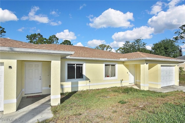 5321-5323 28th St SW, Lehigh Acres, FL 33973 - view of front facade with a garage, a front lawn, stucco siding, and roof with shingles