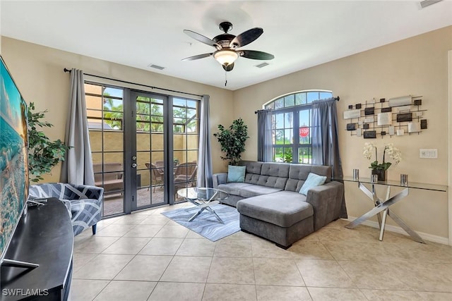 living room with a ceiling fan, french doors, light tile patterned floors, and baseboards