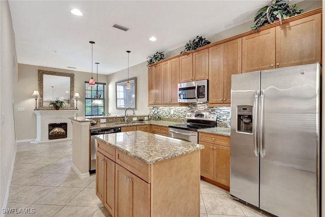 kitchen featuring appliances with stainless steel finishes, light tile patterned floors, a sink, a center island, and a peninsula
