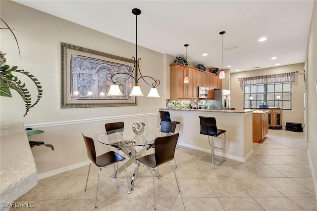 dining room with light tile patterned flooring, recessed lighting, and baseboards
