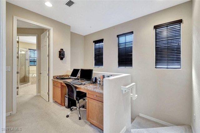 office space featuring light colored carpet, baseboards, and plenty of natural light