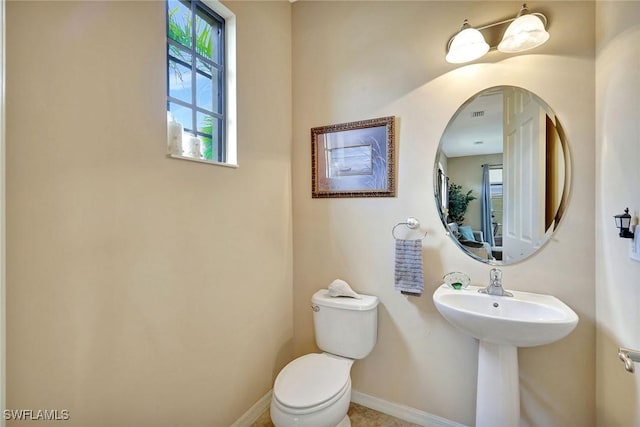 half bathroom with toilet and baseboards