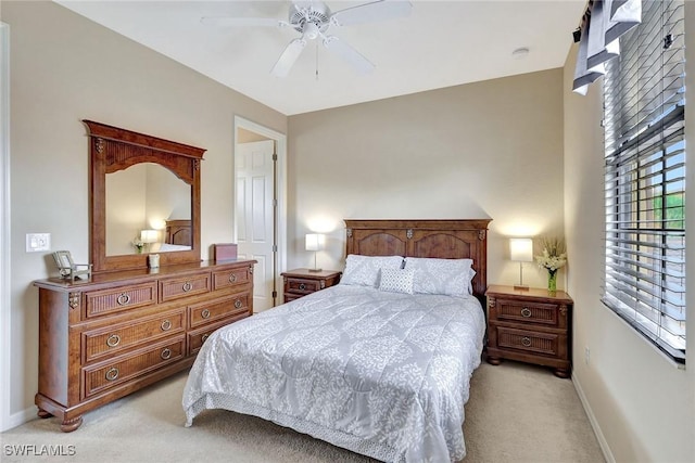 bedroom with light colored carpet, baseboards, and a ceiling fan