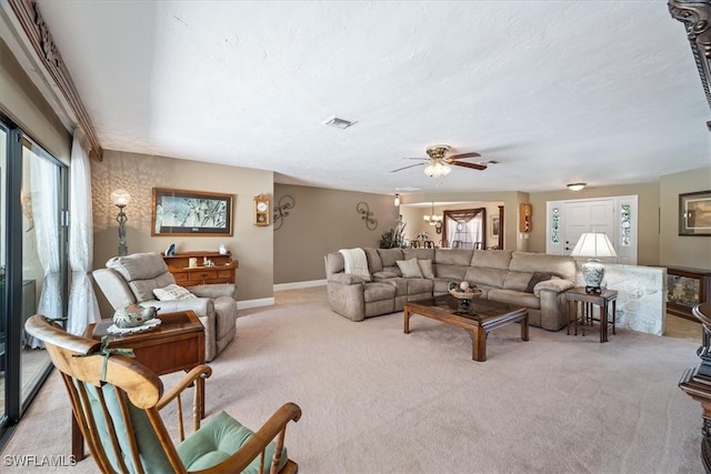 living room featuring light colored carpet, plenty of natural light, a ceiling fan, and a textured ceiling