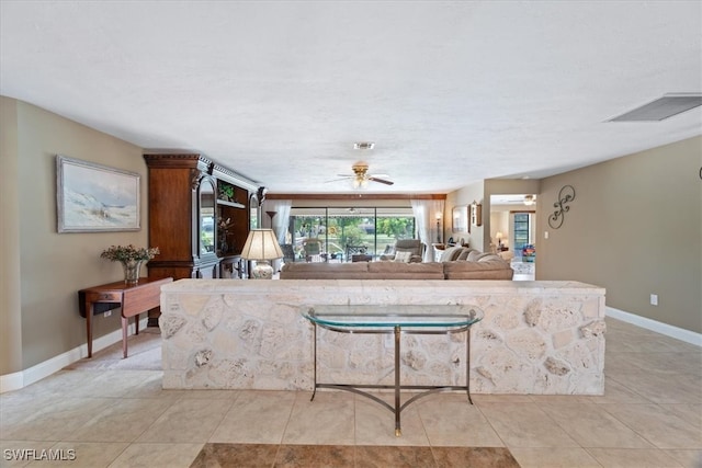 living room featuring light tile patterned flooring, a ceiling fan, and baseboards
