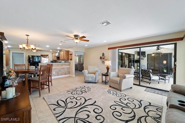 living area featuring light tile patterned flooring, a ceiling fan, a chandelier, and recessed lighting