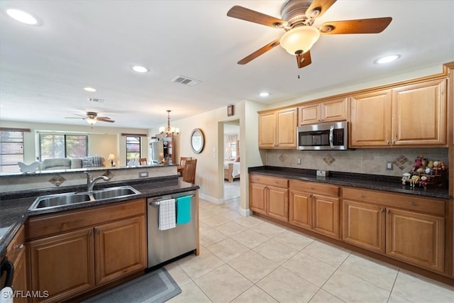 kitchen featuring stainless steel appliances, a sink, a ceiling fan, backsplash, and recessed lighting