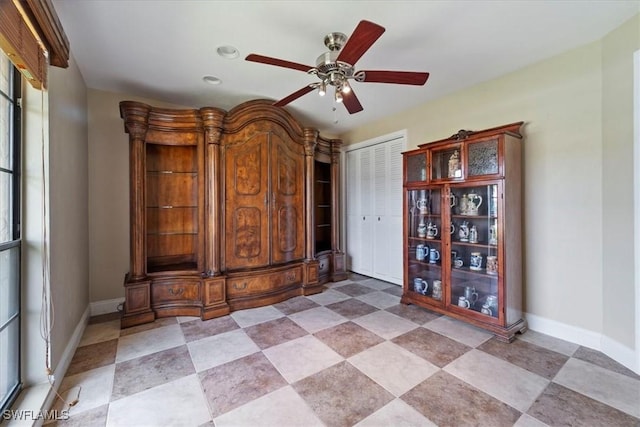 spare room with ceiling fan and baseboards