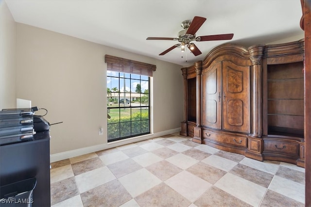 spare room with baseboards and a ceiling fan