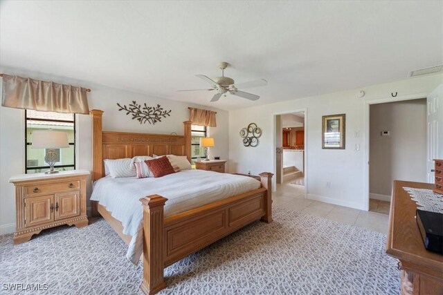 bedroom with baseboards, light tile patterned floors, a ceiling fan, and connected bathroom