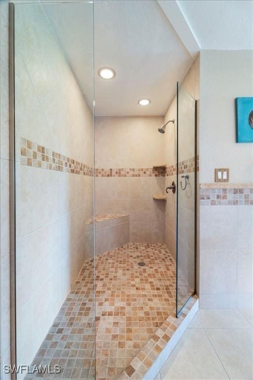 full bathroom featuring tile patterned flooring, tiled shower, tile walls, and recessed lighting