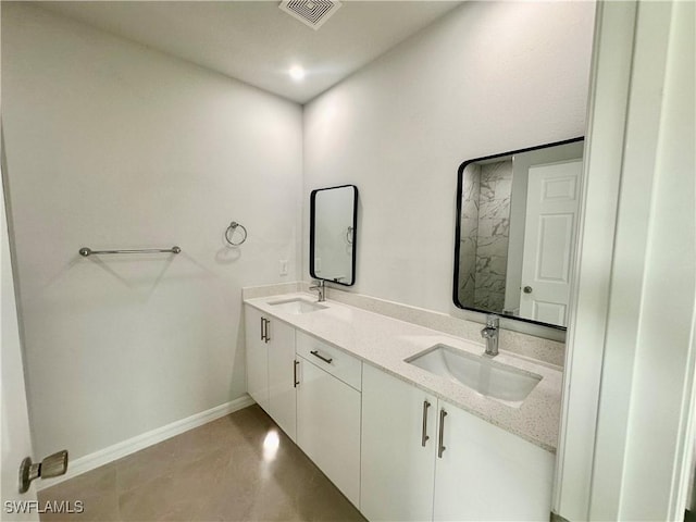 bathroom with baseboards and double vanity