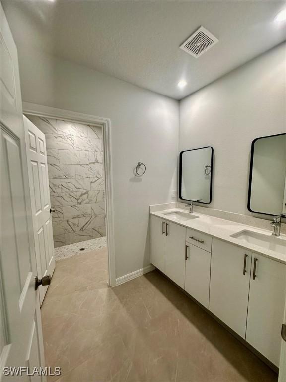 full bathroom featuring double vanity and a walk in shower