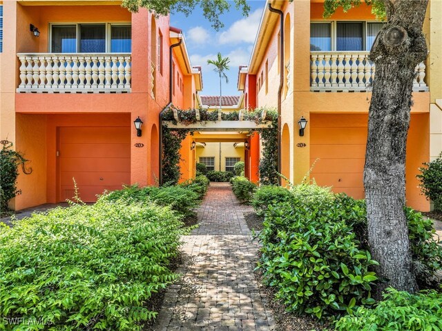 8532 Via Lungomare Cir Unit 203, Estero, FL 33928 - view of front facade featuring an attached garage and stucco siding