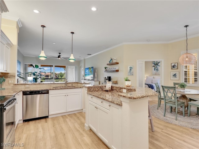 8532 Via Lungomare Cir Unit 203, Estero, FL 33928 - kitchen featuring stainless steel appliances, a sink, healthy amount of natural light, light wood-style flooring, and crown molding