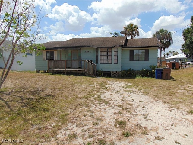 ranch-style house featuring covered porch and a front lawn